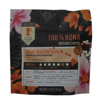 A 2 oz pouch of Aloha Farms Cafe Decaf Healthy Hapa 100% Kona Ground Coffee, featuring a black background decorated with tropical orange and pink flowers, and a detailed label on the front.